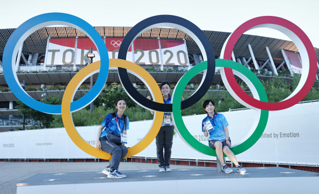 지난 1일 일본 도쿄에서 올림픽 자원봉사자들이 오륜기 모형 앞에서 기념 사진을 찍고 있다./타스연합뉴스
