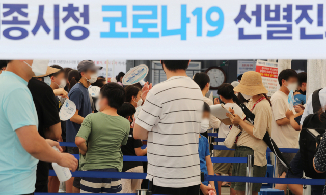 선별진료소에 검사를 받으려는 시민들이 부채로 더위를 식히며 순서를 기다리고 있다./연합뉴스