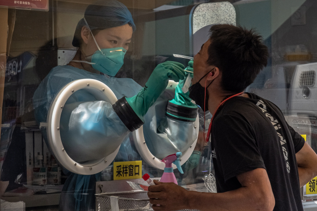 중국 베이징의 한 코로나 19 검사소에서 한 남성이 의료진으로부터 코로나 19 검사를 받고 있다. /EPA연합뉴스