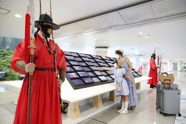 인천공항 제1여객터미널에서 공항 이용객들이 문화유산 방문 캠페인 홍보관 전시를 관람하고 있는 모습/사진제공=인천공항공사