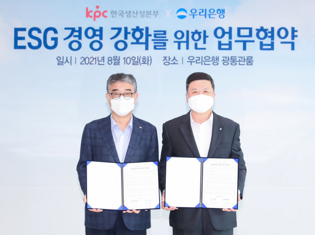 권광석 (오른쪽) 우리은행장과 안완기 한국생산성본부 회장이 지난 10일 서울시 중구 우리은행 본점에서 ‘ESG 경영 강화를 위한 업무협약’ 을 체결한 뒤 협약서를 들어보이고 있다./사진 제공=우리은행