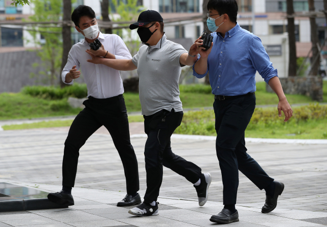 접촉사고 처리부터 하라며 구급차를 막아 응급환자를 사망에 이르게 했다는 논란의 당사자인 택시기사 최모씨가 지난해 7월 24일 서울동부지법에서 열리는 영장실질심사에 출석하고 있다./연합뉴스