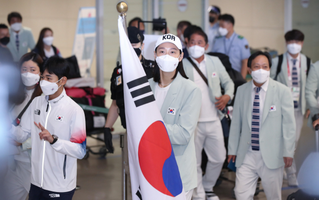 2020 도쿄올림픽 선수단 본진이 9일 오후 인천국제공항 제2터미널을 통해 입국했다. 배구 대표팀 김연경과 근대5종에서 동메달을 획득한 전웅태가 태극기를 들고 선수단과 함께 입국장으로 들어서고 있다. /연합뉴스