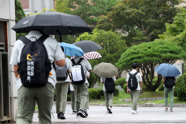 강원 춘천고등학교 학생들이 지난 11일 2학기 개학을 맞아 우산을 쓰고 등교하고 있다. /춘천=연합뉴스