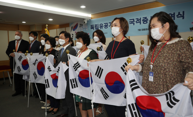 12일 오전 정부과천청사에서 독립유공자 후손들이 법무부로부터 국적증서를 받은 후 기념 촬영을 하고 있다. 법무부는 이날 독립유공자 이명순 선생의 증손 등 모두 25명에게 대한민국 국적증서를 수여했다. /연합뉴스