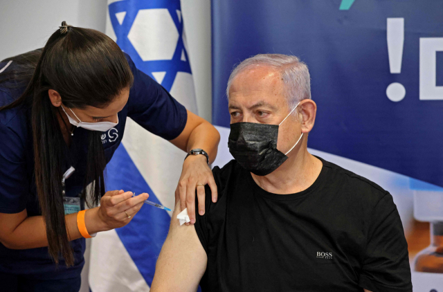 베냐민 네타냐후(오른쪽) 이스라엘 전 총리가 지난달 30일(현지시간) 텔아비브에서 화이자-바이오엔테크의 코로나19 3차 백신(부스터 샷)을 맞고 있다./AFP연합뉴스