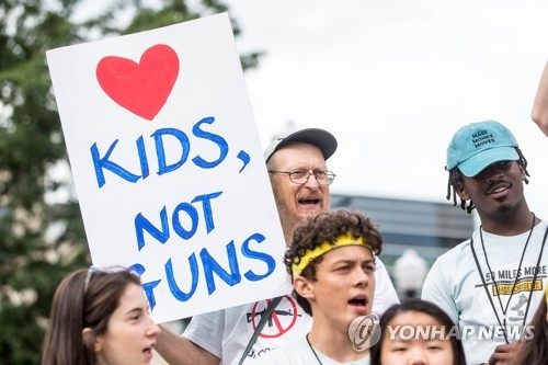 2018년 미국 매사추세츠주(州)에서 벌어진 총기폭력에 반대하는 시위에서 한 참가자가 '총이 아니라 아이들을 사랑하라'라고 적힌 팻말을 들고 있다. /연합뉴스