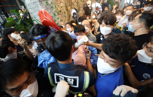 지난 13일 오후 서울 영등포구에 위치한 결제 플랫폼 회사 ‘머지포인트’ 본사에서 환불을 요구하는 가입자들과 빠져나가려는 직원, 경찰이 실랑이를 벌이고 있다./연합뉴스