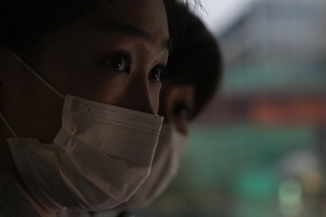 15일 중국 수도 베이징에서 마스크를 쓴 시민들이 거리를 걸어가고 있다. /AP연합뉴스