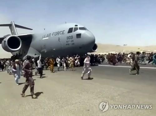 16일(현지시간) 아프가니스탄 수도 카불의 하미드 카르자이 국제공항에서 미군 C-17 수송기가 이륙을 위해 활주로를 따라 이동하자 탑승하지 못한 아프간 시민 수백 명이 수송기를 따라 내달리고 있다. /AP연합뉴스