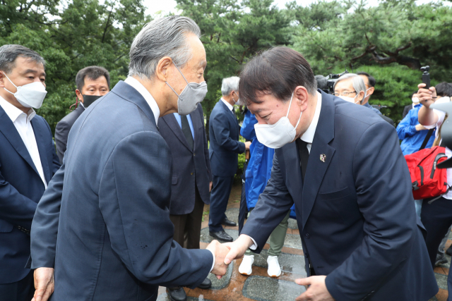 윤석열 국민의힘 대선 예비후보가 김대중 전 대통령 서거 12주기인 18일 서울 동작구 국립서울현충원을 방문, 김 전 대통령 묘역을 참배한 뒤 권노갑 김대중기념사업회 이사장과 인사하고 있다./연합뉴스