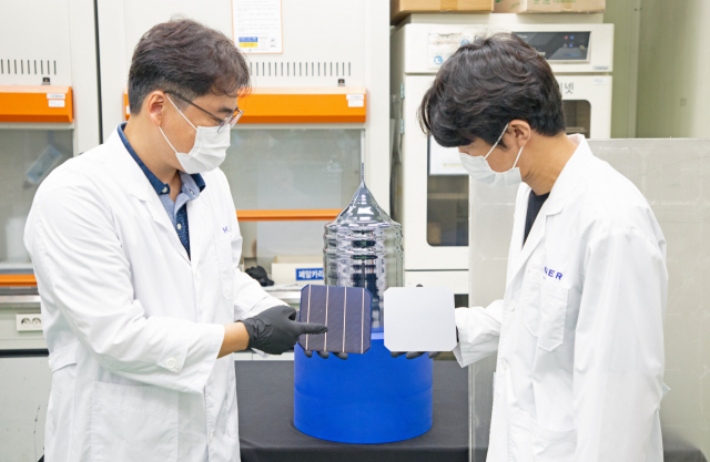 한국에너지기술연구원 이진석(사진 왼쪽) 책임연구원과 이준규(″오른쪽) 연구원이 태양광 폐패널로부터 회수한 실리콘을 재활용해 만든 웨이퍼와 태양전지를 들고 있다. 사진제공=한국에너지기술연구원