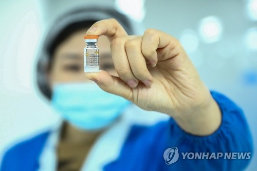 중국 제약사 시노백 바이오테크의 직원이 지난해 12월 23일 자사의 신종코로나바이러스 감염증(코로나19) 백신을 들어보이고 있다. /연합뉴스