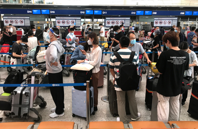 국제 항공편을 탑승하려는 승객들이 18일 중국 베이징 서우두공항에서 길게 줄을 서 있다. /UPI연합뉴스