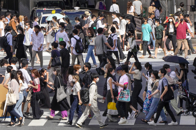 일본 수도 도쿄 시내에서 18일 코로나19 예방 마스크를 쓴 행인들이 횡단보도를 걷고 있다. /연합뉴스