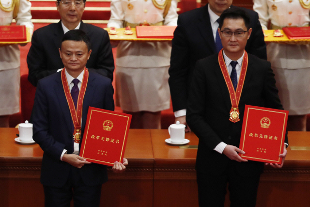 마윈(왼쪽) 알리바바 창업자와 마화텅 텐센트 창업자 겸 회장이 지난 2018년 12월 18일 베이징 인민대회당에서 진행된 중국 ‘개혁개방’ 40주년 기념식의 공로자로 선정돼 상장을 받고 기념촬영하고 있다. 2년여가 흐른 지금 두 사람을 둘러싼 상황은 많이 바뀌었다. /로이터연합뉴스