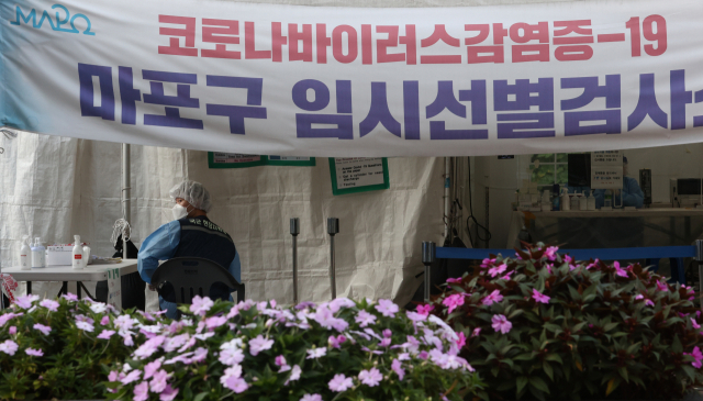 지난 18일 오후 꽃길이 조성된 서울 마포구 서강대역사 광장 임시선별검사소에서 의료진이 업무를 보고 있다./연합뉴스