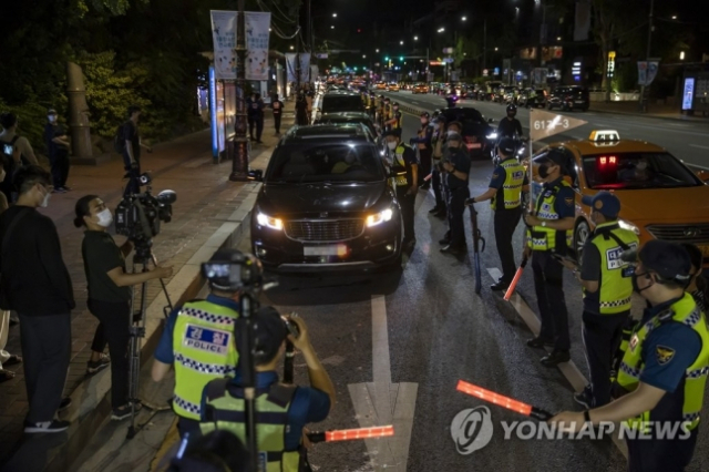 지난 7월 15일 새벽 전국자영업자비대위 소속 회원 등이 서울 종로구 마로니에공원 일대에서 비상등을 켠 채 정부의 ‘거리두기 4단계 조치’에 불복하는 1인 차량 시위를 하고 있다. /연합뉴스