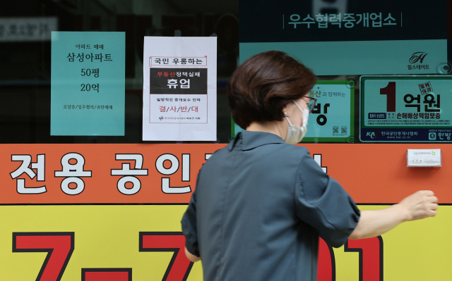 정부가 부동산 중개 수수료 개편을 마련 중인 가운데 19일 서울 시내의 한 부동산중개업소에서 관계자가 휴업 안내문을 붙이고 있다. /연합뉴스