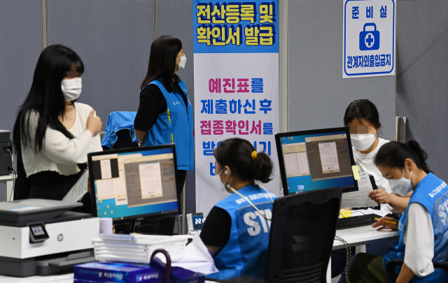 20일 서울 동작구 코로나19 예방접종센터에서 백신 접종을 마친 시민들이 접종확인서를 발급받고 있다. /오승현 기자
