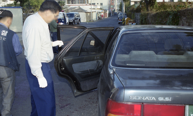 지난 1999년 11월 경찰이 변호사 피살사건이 발생한 제주시 삼도2동 제주북초 북쪽 삼거리에 세워진 승용차에 대해 감식하고 있다. /연합뉴스=한라일보 제공