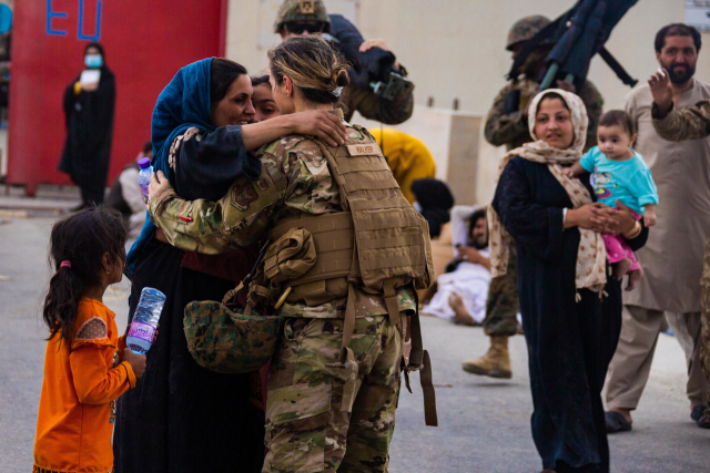 A U.S. Airman with the Joint Task Force-Crisis Response embraces mother after helping reunite their family at Hamid Karzai International Airport, in Kabul, Afghanistan, on August 20, 2021. U.S. service members are assisting the Department of State with a Non-combatant Evacuation Operation (NEO) in Afghanistan. Photo by Cpl. Davis Harris/USMC/UPI