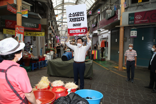 국민의힘 대선주자인 원희룡 전 제주지사가 지난 20일 대구 남구 관문시장을 찾아 '소상공인, 자영업자 여러분 미안합니다'라고 쓰인 피켓을 들고 있다. /연합뉴스