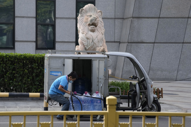 23일 중국 베이징의 한 거리에서 한 남성이 생수 배달을 준비하고 있다. /AP연합뉴스