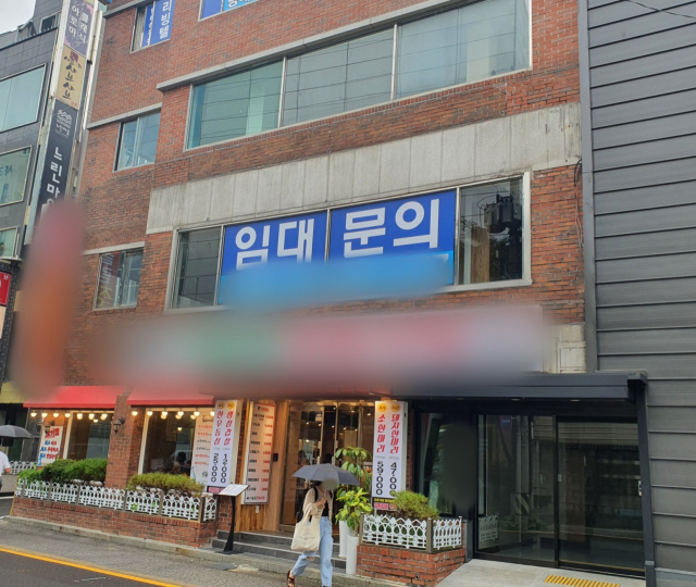 우산을 쓴 시민이 23일 오후 서울 서초구의 한 식당 건물 앞을 지나고 있다. 김 모(59) 씨는 지난 2월 설 연휴까지 이 건물 1층과 3층에서 보쌈집 본점을 운영했다. 김 씨는 코로나19 이후 본점을 폐점하고 인근 별관에서만 영업을 하고 있다. /사진=김태영 기자