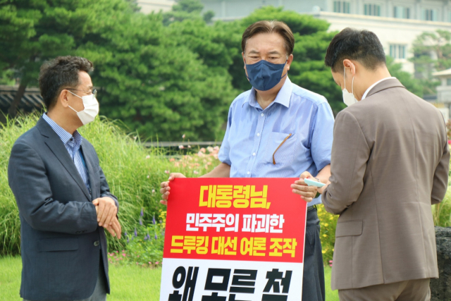 이철희 청와대 정무수석(왼쪽)이 지난달 29일 오전 서울 종로구 청와대 사랑채 앞에서 '드루킹 댓글 사건' 관련 1인 시위를 벌이고 있는 정진석 국민의힘 의원을 찾고 있다./연합뉴스