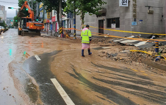 제12호 태풍 오마이스가 지나간 24일 오전 부산 연제구 양정교차로 인근 일부 구간 도로가 폭우에 파손되고 토사가 유입돼복구 작업이 진행 중이다. /사진 제공=부산경찰청