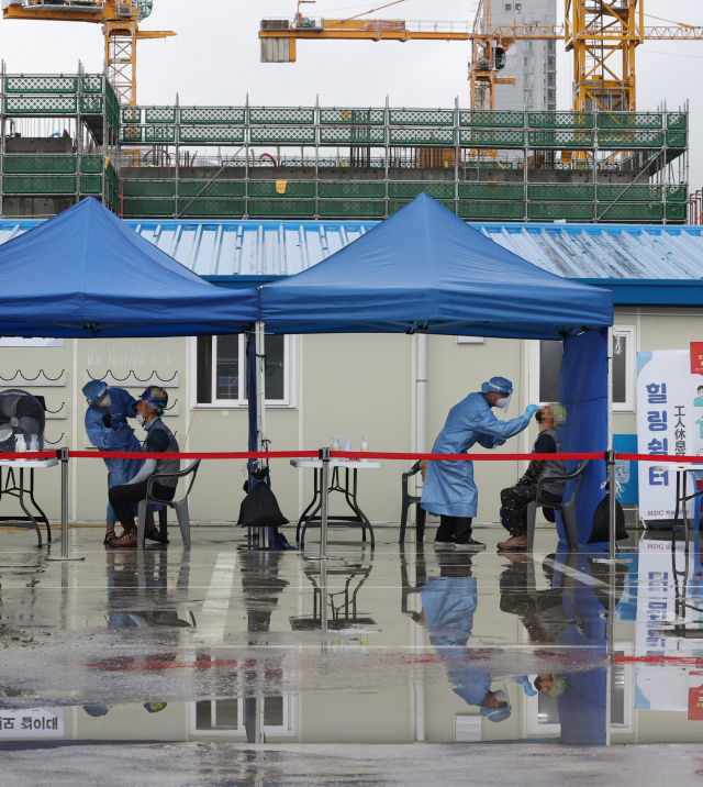 24일 서울 강동구 한 아파트 공사현장에 설치된 선별진료소에서 근로자들이 검사를 받고 있다. /연합뉴스