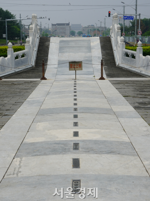 베이징 중축선의 남단 ‘천교’ 앞의 바닥에 ‘北京中軸’이라는 글자들이 박혀 있다. 멀리 보이는 건물은 정양문이다. /최수문기자