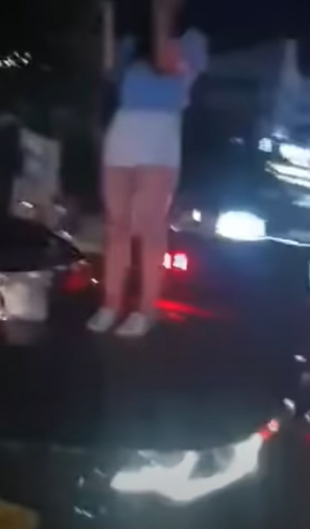 지난 22일 오후 10시 30분께 울산시 남구 삼산동 한 사거리에서 만취한 20대 여성이 택시 위에 올라 소란을 피우고 있다. /유튜브 캡쳐
