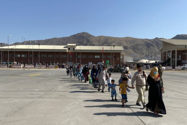 한국 정부와 협력한 아프가니스탄인들이 24일(현지시간) 국내 이송을 위해 카불 공항에 도착한 한국 공군 수송기로 이동하고 있다. /연합뉴스