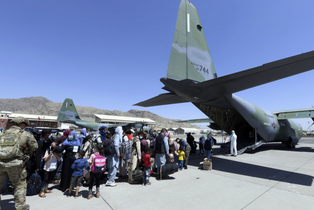 한국으로 이송될 아프간 현지 조력자와 가족들이 지난 25일 아프가니스탄 카불공항에서 공군 C-130J 수퍼허큘리스 수송기에 탑승하기 위해 대기하고 있다./연합뉴스