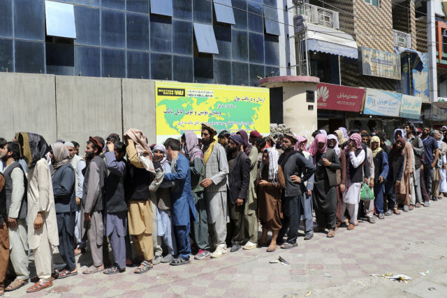 25일(현지 시간) 아프가니스탄 카불은행 앞에 이곳을 이용하려는 사람들이 줄지어 서있다./AP연합뉴스