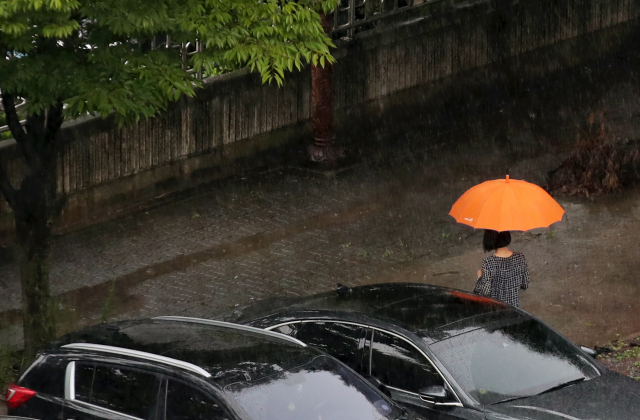 정체전선의 영향으로 가을장마가 이어지고 있는 25일 광주 서구 치평동에서 우산을 쓴 시민이 지나고 있다. /광주=연합뉴스
