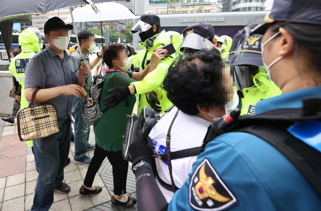 서울 성북구 사랑제일교회 신자들이 현장 예배를 위해 지난 22일 서울 광화문 동화면세점 앞으로 모이던 중 경찰과 대치하고 있다. /연합뉴스