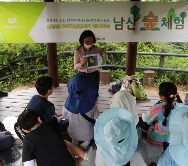 26일 남산숲 유아숲체험장에서 환경교육 전문 강사가 신당꿈지역아동센터 아동을 대상으로 체험교육을 진행하고 있다./사진 제공=동국제강