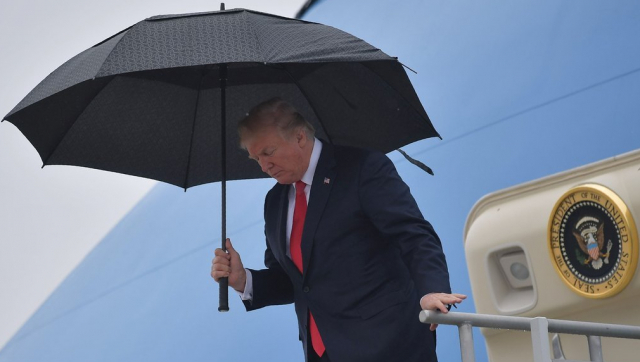도널드 트럼프 전 미국 대통령이 지난 2018년 전용기 에어포스원에서 우산을 쓰고 이동하는 모습, /AFP연합뉴스
