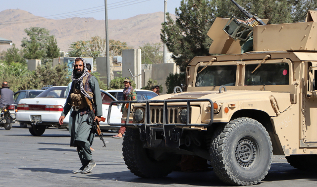 아프가니스탄 수도 카불에서 27일(현지시간) 이슬람 무장세력 탈레반 병사들이 하미드 카르자이 국제공항으로 진입하는 도로를 장갑차로 막고 경비를 서고 있다. /EPA연합뉴스