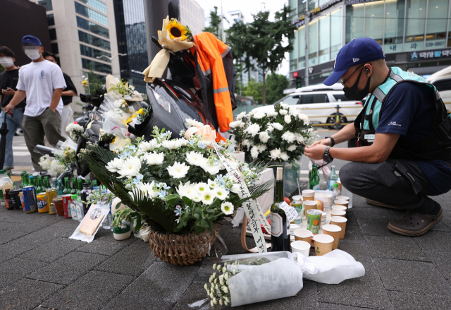 27일 오후 서울 강남구 선릉역 인근 도로에 전날 사망한 오토바이 배달원을 추모하는 국화꽃 등이 놓여져 있다. /연합뉴스