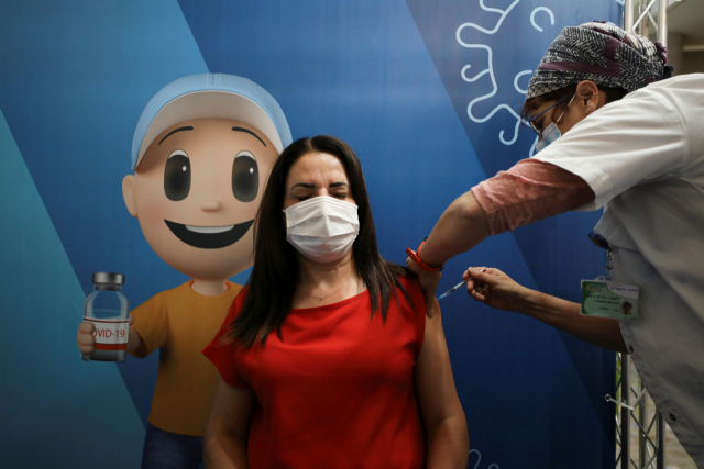 지난 13일(현지 시간) 한 여성이 이스라엘에서 코로나19 백신 3차 접종을 받고 있다./로이터연합뉴스
