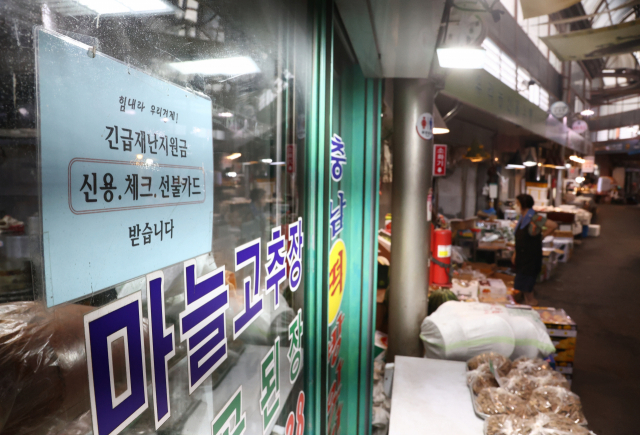 26일 서울 종로구 통인시장 점포에 긴급재난지원금 관련 안내문이 붙어 있다. /연합뉴스