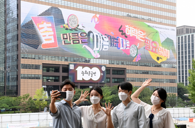 30일 서울 종로구 세종문화회관에서 교보 직원들이 교보빌딩에 100번째 광화문 글판 게시를 기념해 글판을 배경으로 기념촬영을 하고 있다. 100번째 광화문 글판은 BTS의 노래 '퍼미션 투 댄스'의 '[춤]만큼은 마음 가는 대로, 허락은 필요 없어'라는 노랫말을 인용했다. 디자인에는 미디어 아티스트인 이예승 작가가 참여했다./권욱 기자 2021.08.30