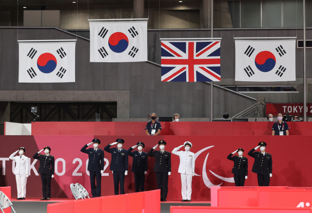 30일 일본 도쿄 메트로폴리탄 체육관에서 열린 2020 도쿄 패럴림픽 남자 탁구 단식 시상식에서 태극기 3개가 게양되고 있다. /연합뉴스