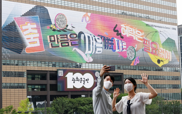30일 서울 종로구 세종문화회관에서 교보생명 직원들이 교보빌딩에 100번째 광화문글판 게시를 기념해 글판을 배경으로 기념 촬영을 하고 있다. /권욱 기자