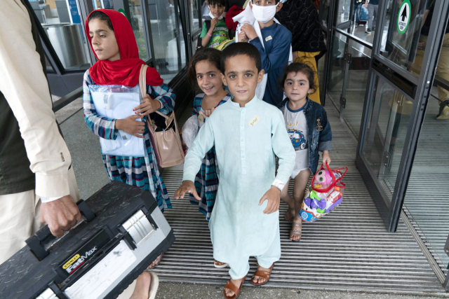 이슬람 무장세력 탈레반이 장악한 아프가니스탄을 탈출한 피란민 가족의 어린이들이 26일(현지시간) 미국 버지니아주 챈틸리의 덜레스 국제공항에 도착해 버스에 오르면서 웃음 짓고 있다. /AP연합뉴스