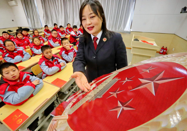 중국 허베이성 칭황다오의 한 초등학교에서 국가휘장에 대해 설명하고 있다. /AFP연합뉴스